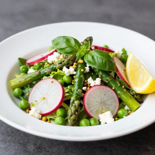 Professional spring salad plated on a white dish showing perfect texture and color balance