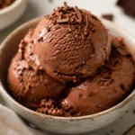 Chocolate cottage cheese ice cream scooped into a bowl with chocolate shavings, a creamy high-protein dessert.