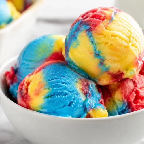 Superman Ice Cream with red, blue, and yellow scoops in a white bowl