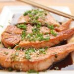 Glossy honey garlic glazed salmon fillet plated with a rich, sticky sauce