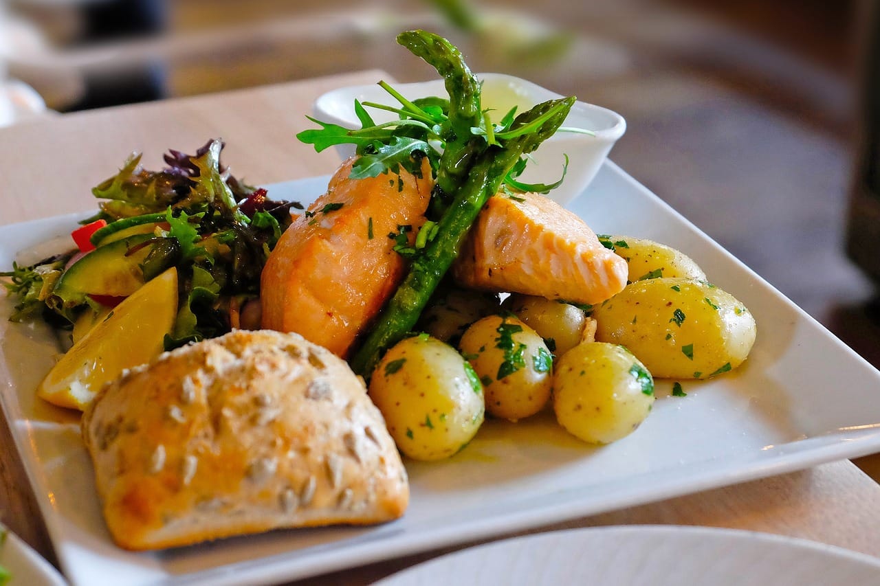 Plated salmon dinner with roasted potatoes and vegetables, ready to serve